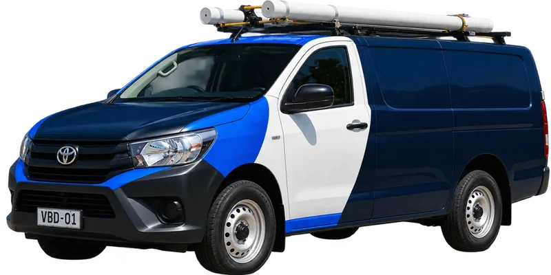 A licensed the Inner West plumbing van loaded with pipe on the roof rack